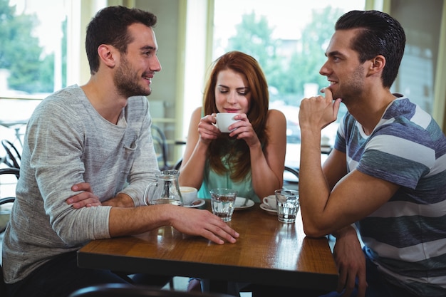 Amigos que interactúan mientras se toma una taza de café