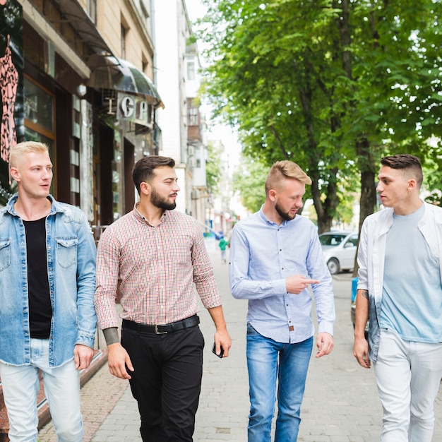 Amigos que miran al hombre que señala el dedo al aire libre