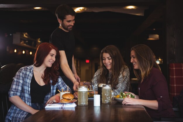 Amigos que tienen comida en el bar