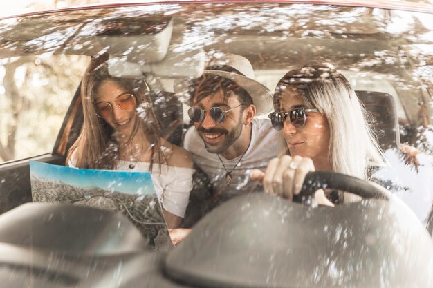 Amigos que viajan en coche mirando el mapa