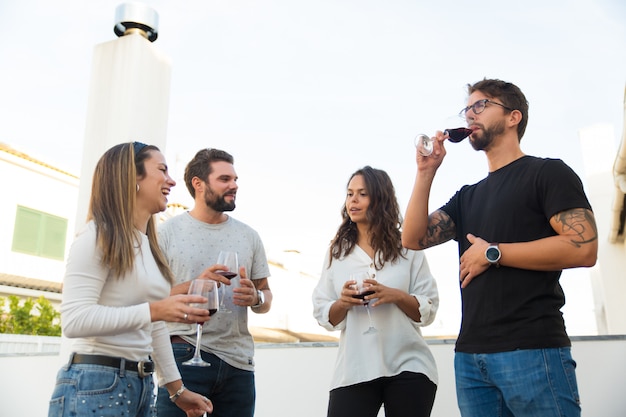 Amigos relajados bebiendo vino y discutiendo noticias