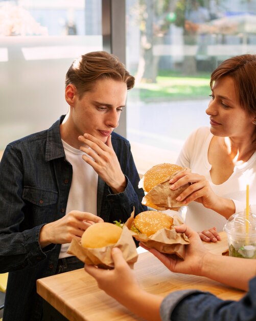 Amigos en el restaurante de comida rápida comiendo