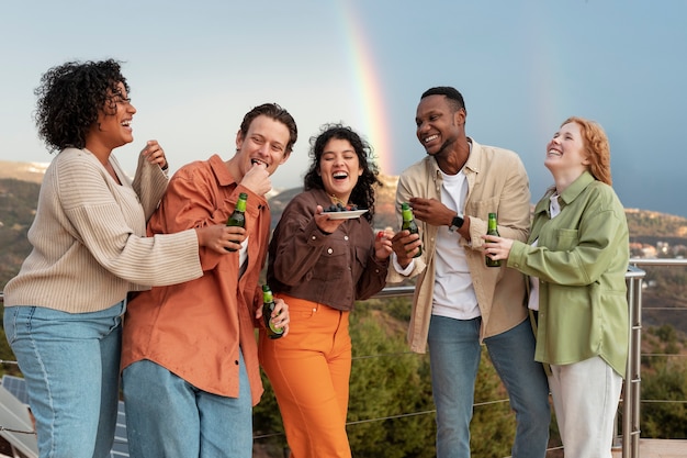 Amigos riendo y bebiendo cerveza durante la fiesta al aire libre