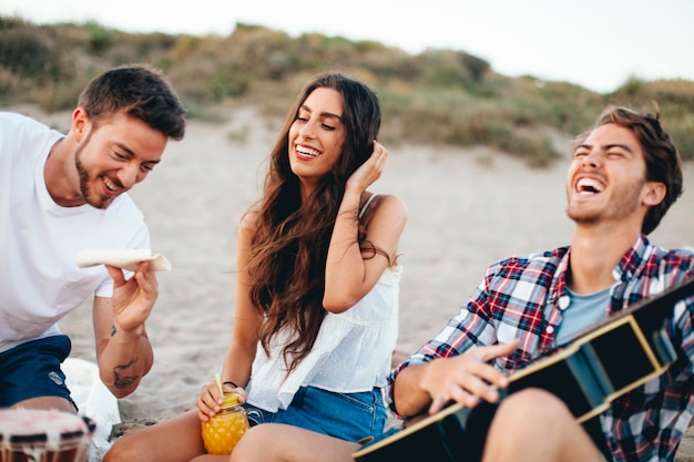 Amigos riendo juntos en la playa