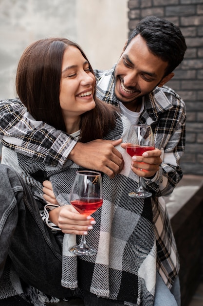 Amigos riendo y sosteniendo dos copas de vino