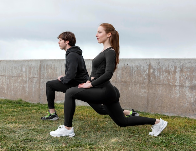 Foto gratuita amigos en ropa deportiva haciendo ejercicio al aire libre