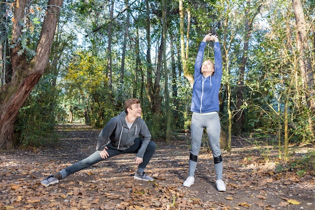 Amigos en ropa deportiva haciendo estiramientos en un día soleado