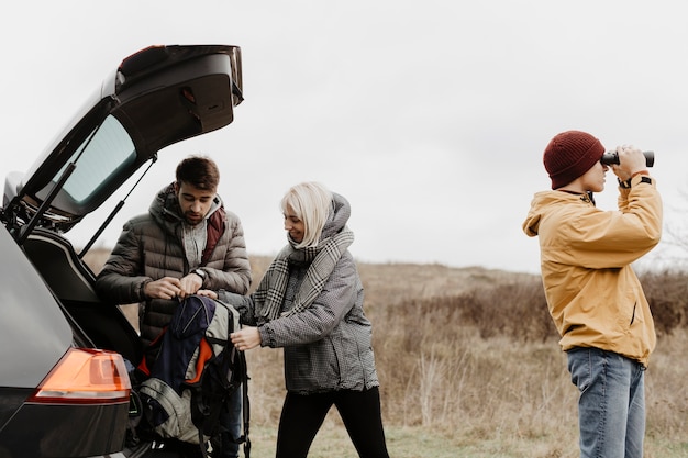 Amigos sacando mochila del coche