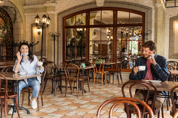 Amigos saludando el uno al otro respetando la distancia social