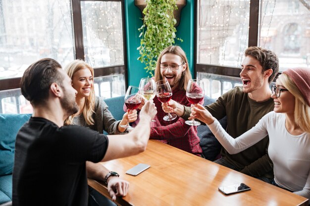 Amigos sentados en la cafetería y beber alcohol.