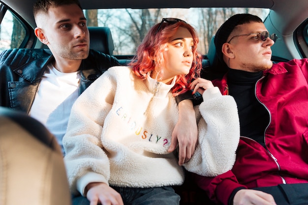 Amigos sentados en el coche y mirando a la ventana