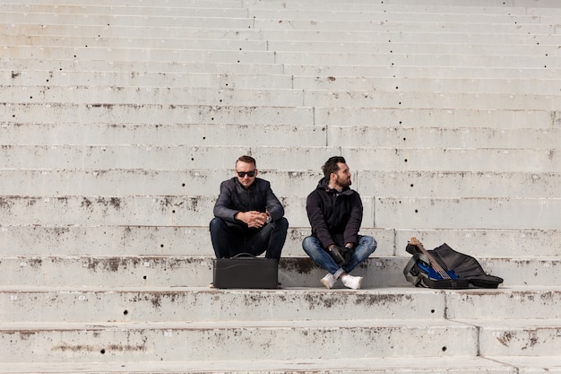 Amigos sentados en escaleras de cemento