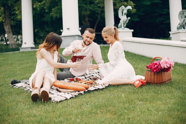 Amigos sentados en un jardín en un picnic