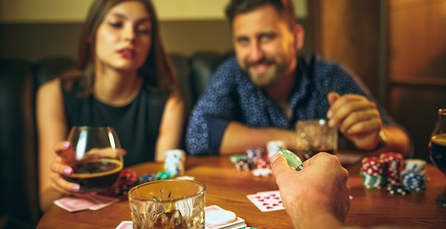 Amigos sentados en la mesa de madera. Amigos que se divierten jugando al juego de mesa.