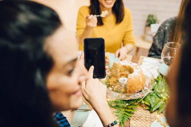 Amigos con smartphone y tarta