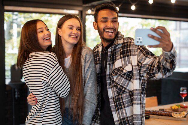 Amigos sonriendo y tomando un selfie en una reunión