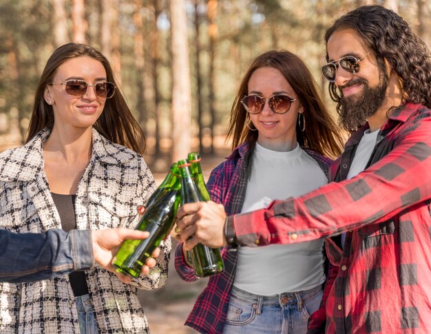 Amigos sonrientes brindando con cerveza al aire libre