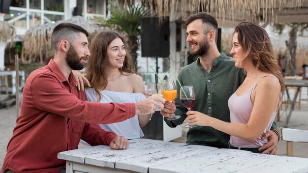 Amigos sonrientes brindando plano medio