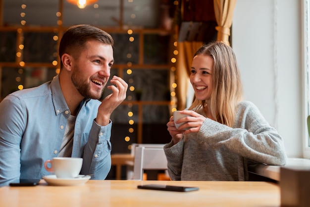 Amigos sonrientes charlando y tomando café