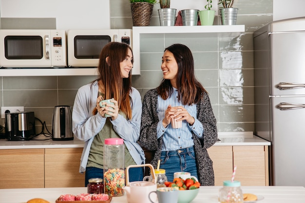 Amigos sonrientes desayunando en la cocina