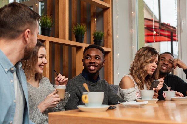 Amigos sonrientes disfrutando de una taza de café