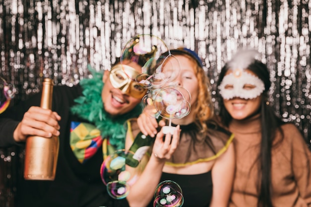 Amigos sonrientes divirtiéndose en la fiesta de carnaval