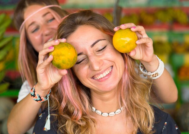 Amigos sonrientes divirtiéndose juntos en el mercado de agricultores