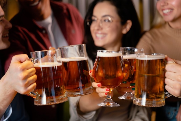 Foto gratuita amigos sonrientes de primer plano con jarras de cerveza