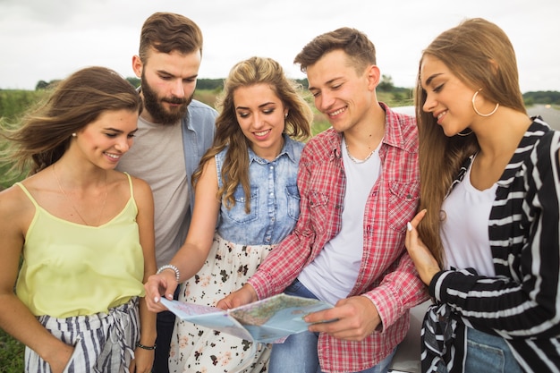 Amigos sonrientes que estudian el mapa