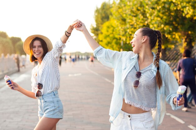 Amigos sonrientes que sostienen sus manos afuera