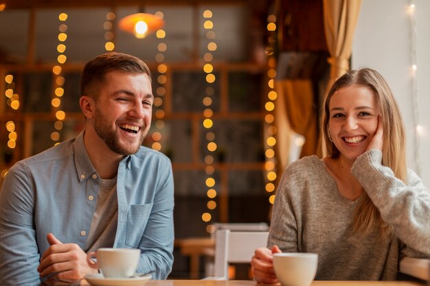 Amigos sonrientes en el restaurante tomando café