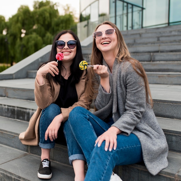 Foto gratuita amigos sonrientes sentados en las escaleras