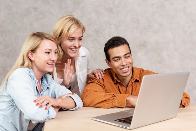 Foto gratuita amigos sonrientes teniendo una videollamada