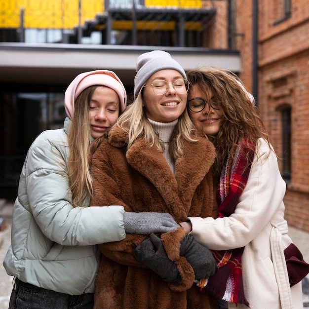 Amigos sonrientes de tiro medio abrazándose