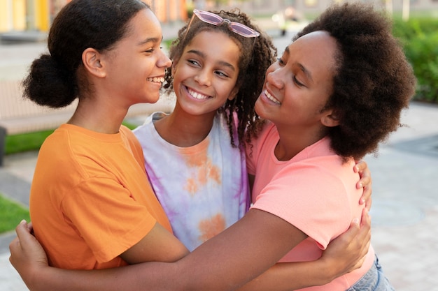 Amigos sonrientes de tiro medio abrazándose