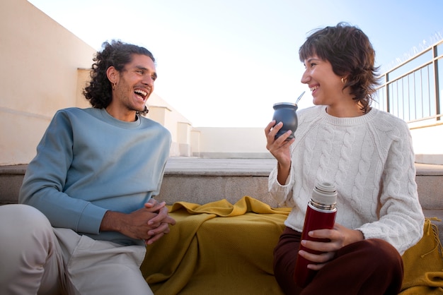 Foto gratuita amigos sonrientes de tiro medio con bebida