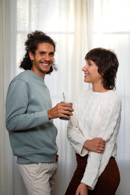 Amigos sonrientes de tiro medio con bebida