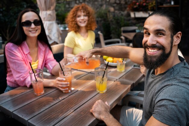 Amigos sonrientes de tiro medio con bebidas