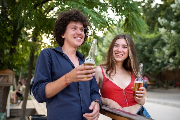 Amigos sonrientes de tiro medio con bebidas