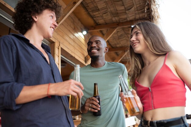 Amigos sonrientes de tiro medio con bebidas