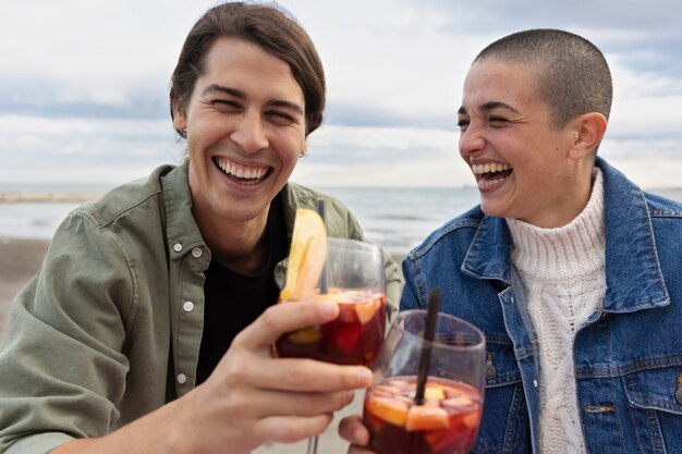 Amigos sonrientes de tiro medio con bebidas