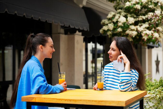 Amigos sonrientes de tiro medio con bebidas