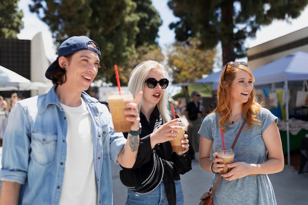 Amigos sonrientes de tiro medio con bebidas