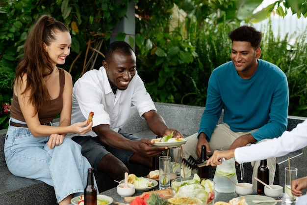 Amigos sonrientes de tiro medio con comida