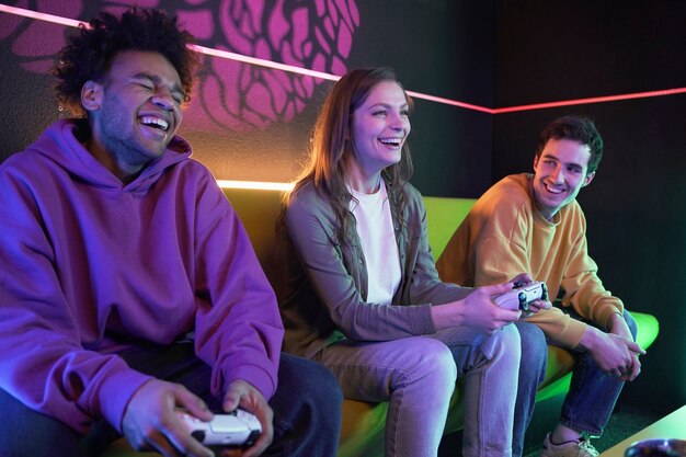 Amigos sonrientes de tiro medio jugando videojuegos