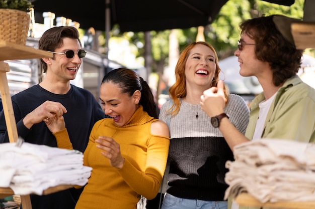 Amigos sonrientes de tiro medio en el mercado de pulgas