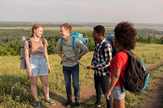 Amigos sonrientes de tiro medio en la naturaleza