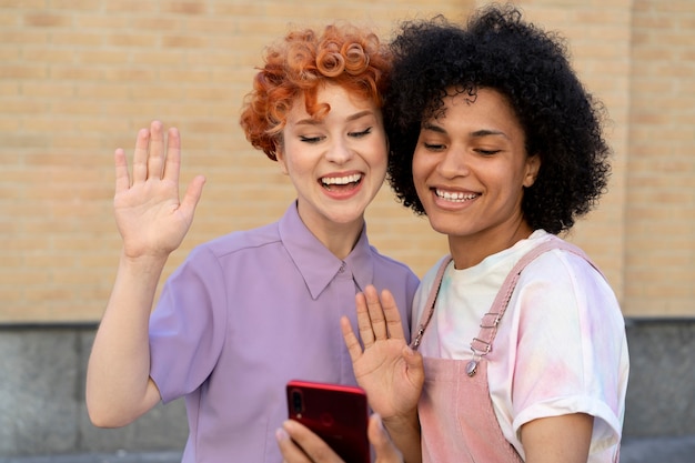 Amigos sonrientes de tiro medio con smartphone