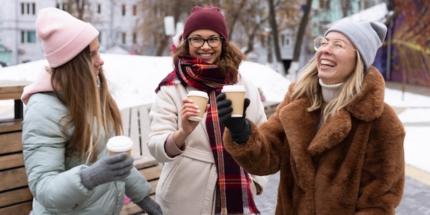 Amigos sonrientes de tiro medio con tazas de café