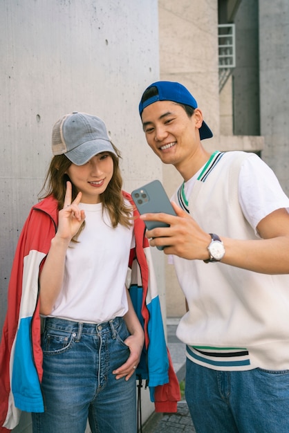 Foto gratuita amigos sonrientes de tiro medio tomando selfie al aire libre